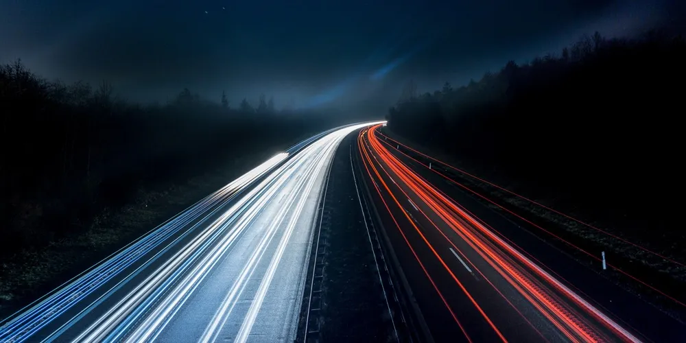 Long exposure photo of a highway at night, showcasing light trails and emphasizing Legacy System Support